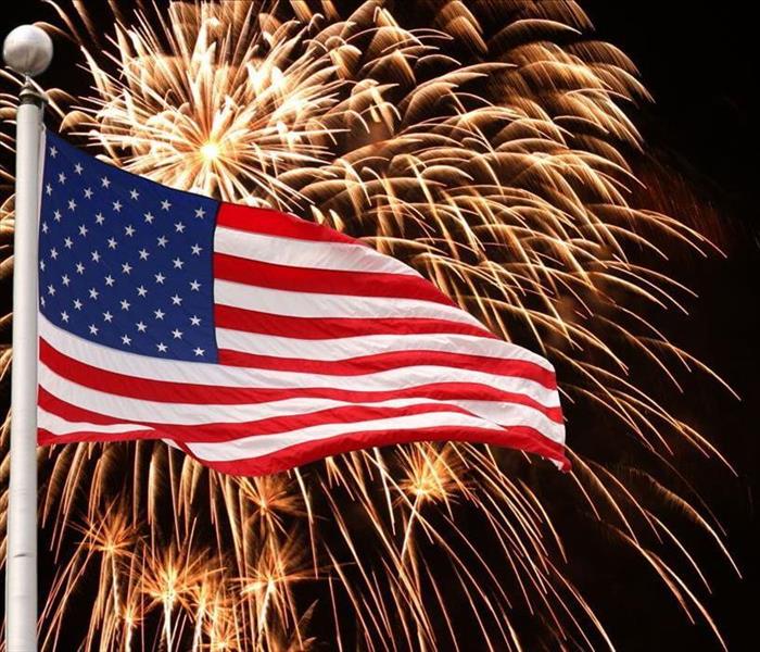 American Flag in front of orange fireworks