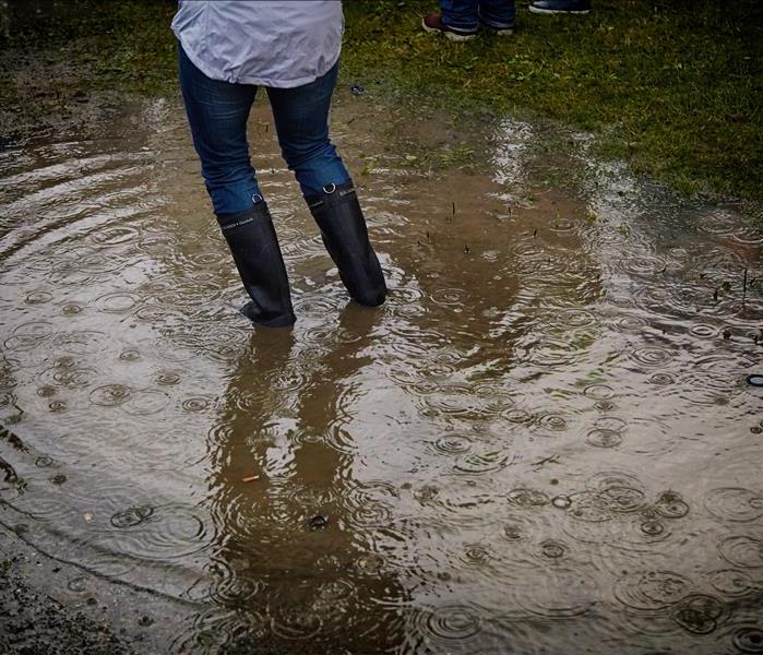 Woman wearing rain boots standing in water
